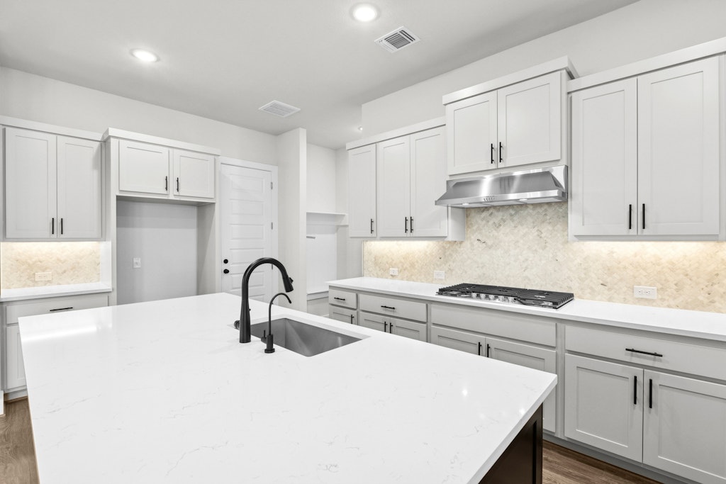 19600 Judys View Pflugerville, TX 78660 - Photo 13 of 34 a kitchen with kitchen island a sink a stove and cabinets