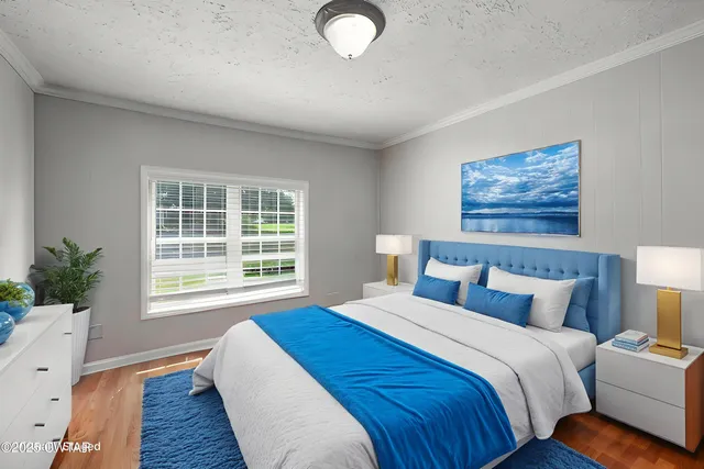 a bedroom with bed and wooden floor