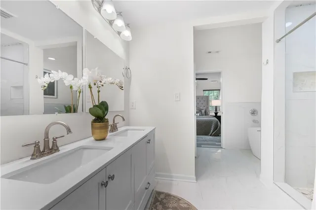 a bathroom with a sink a potted plant and a mirror