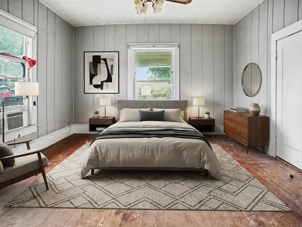 a view of a room with a large window and wooden floor