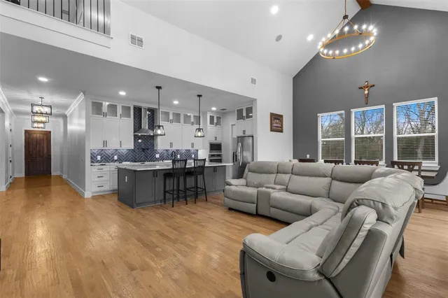 a living room with furniture a chandelier and a dining room