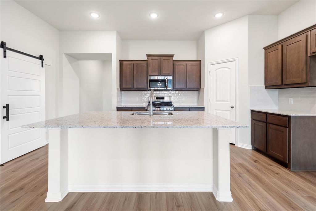 3508 Columbus Street Gainesville, TX 76240 - Photo 11 of 38 a kitchen with kitchen island granite countertop a sink stove and refrigerator