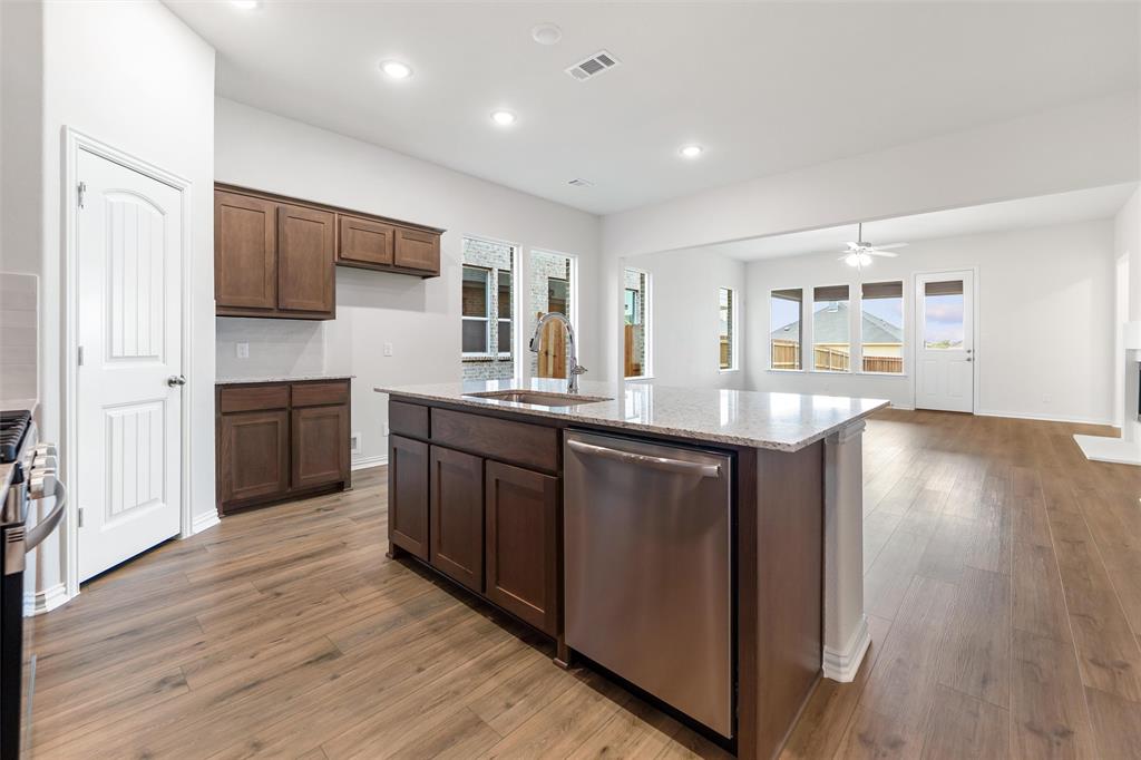 3508 Columbus Street Gainesville, TX 76240 - Photo 14 of 38 a kitchen with kitchen island granite countertop wooden floors and stainless steel appliances
