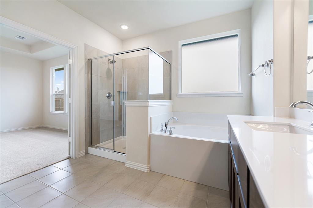 3508 Columbus Street Gainesville, TX 76240 - Photo 27 of 38 a bathroom with a tub a sink and a large mirror