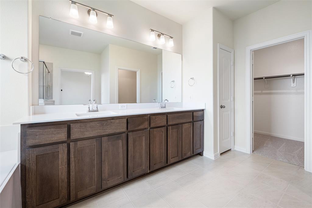3508 Columbus Street Gainesville, TX 76240 - Photo 30 of 38 a bathroom with a double vanity sink and a mirror