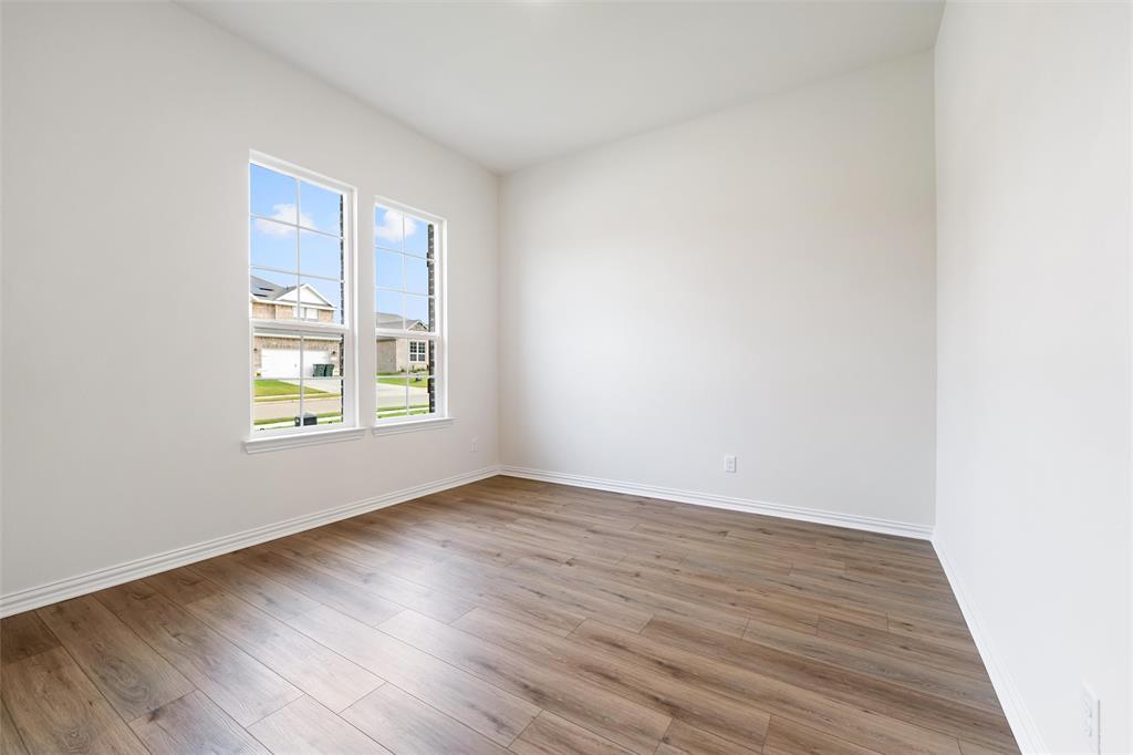 3508 Columbus Street Gainesville, TX 76240 - Photo 9 of 38 an empty room with wooden floor and windows