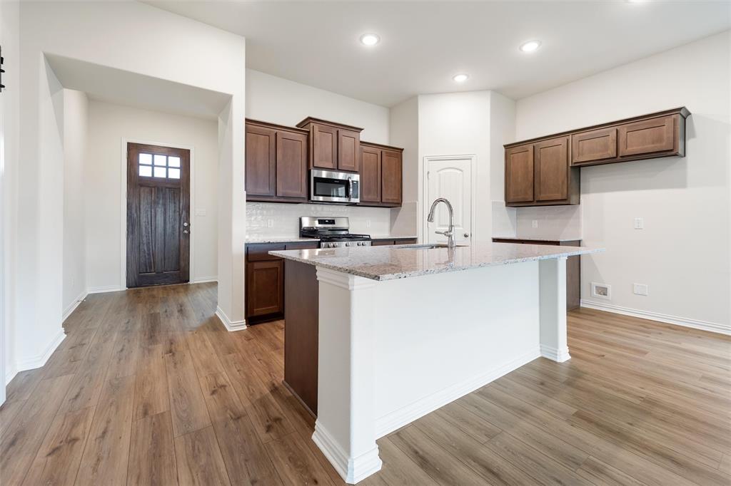 3508 Columbus Street Gainesville, TX 76240 - Photo 10 of 38 a kitchen with wooden floors appliances and cabinets