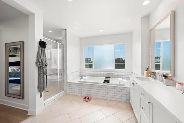 a bathroom with a tub a sink and mirror