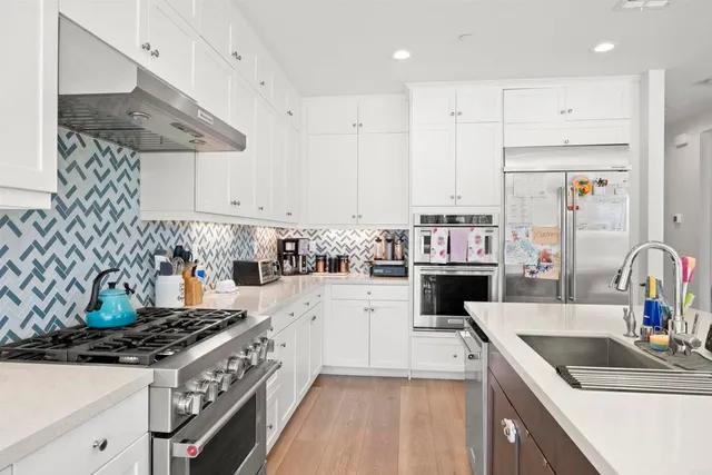 a kitchen with stainless steel appliances a stove a sink and a refrigerator