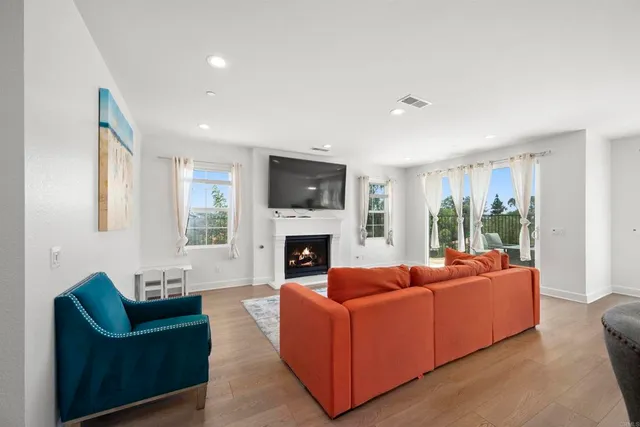 a living room with fireplace furniture and a large window
