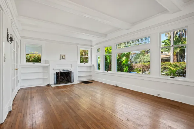 a view of empty room with wooden floor and fireplace