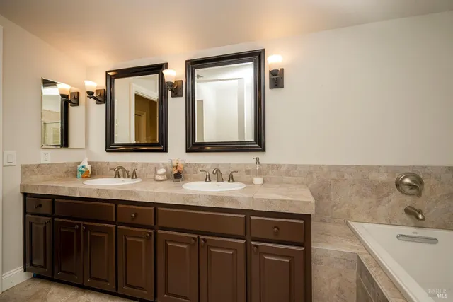 a bathroom with a double vanity sink and mirror