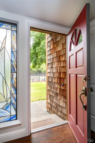 a view of an entryway with wooden floor and a front door