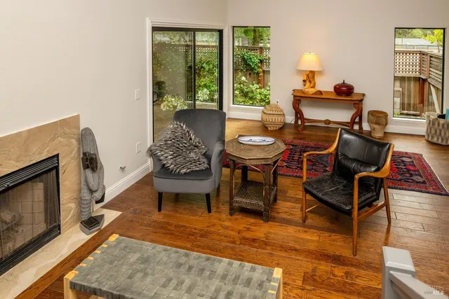 a living room with furniture a fireplace and a floor to ceiling window