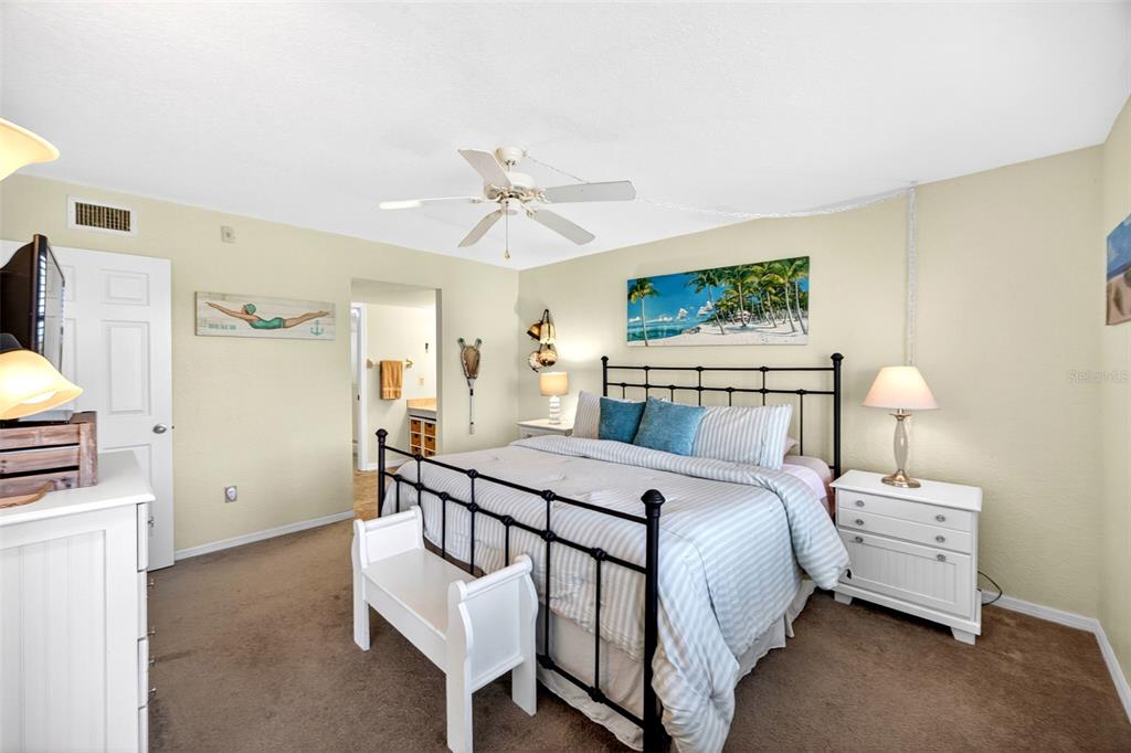 175 Kings Highway, Unit 516 Punta Gorda, FL 33983 - Photo 18 of 37 a bedroom with a bed a couch and a flat screen tv