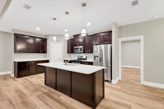 a large kitchen with kitchen island a sink stainless steel appliances and cabinets