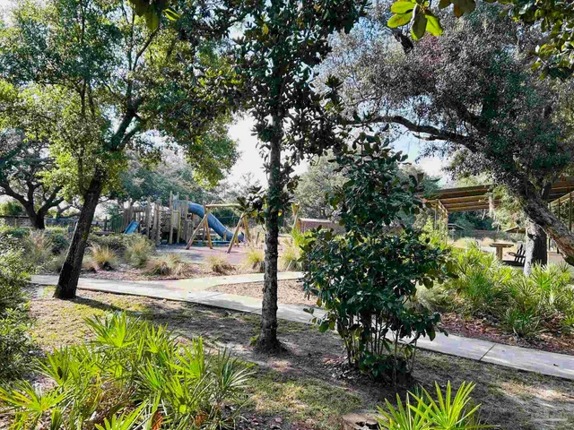 a sign board with tall trees
