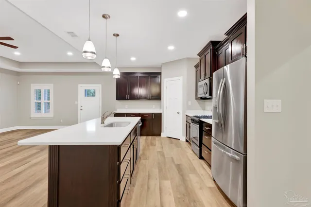 a kitchen with kitchen island a counter top space stainless steel appliances and a refrigerator