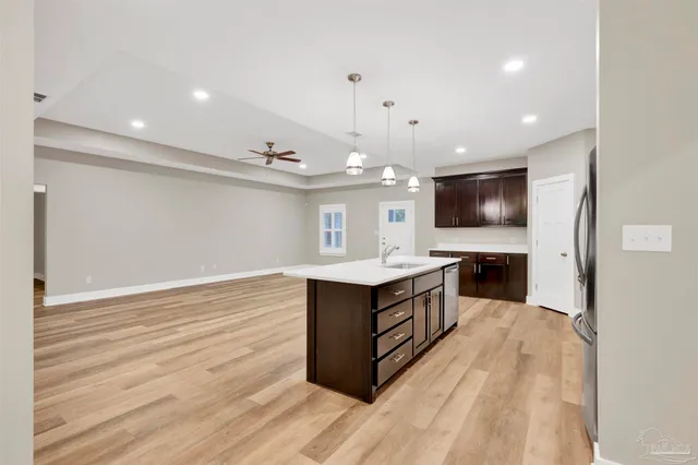 a kitchen with stainless steel appliances granite countertop a sink stove and wooden floor