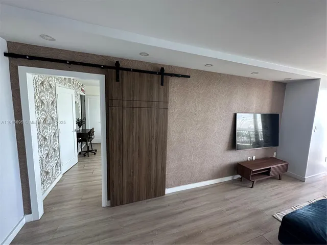 a view of a livingroom with wooden floor and furniture