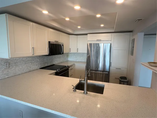 a kitchen with stainless steel appliances a refrigerator sink and microwave