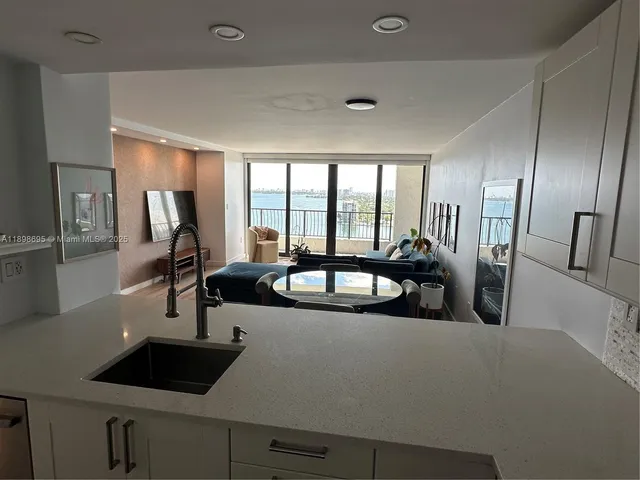 a view of a sink and dishwasher with wooden floor