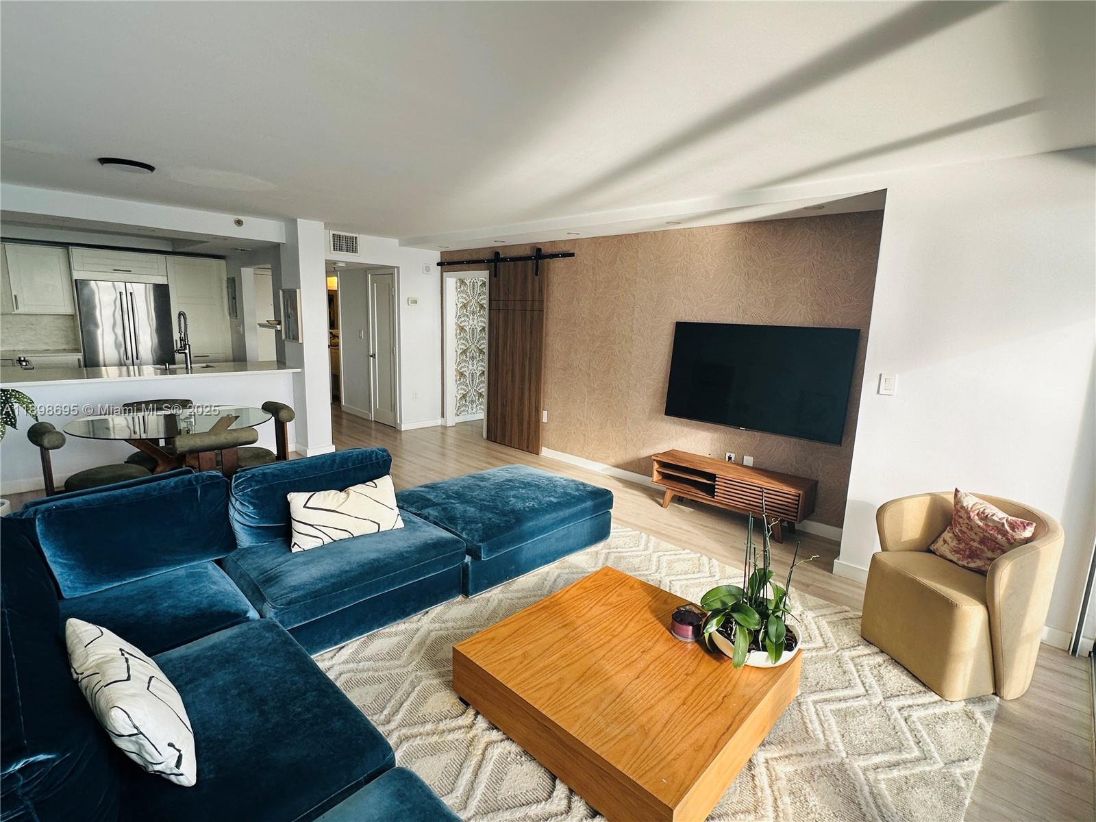 555 Northeast 15th Street, Unit 23B Miami, FL 33132 - Photo 6 of 32 a living room with furniture and a flat screen tv