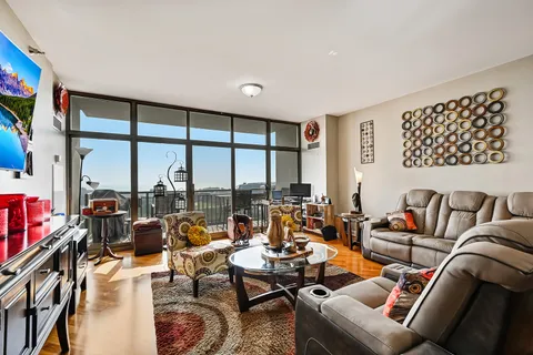 a living room with furniture and a floor to ceiling window
