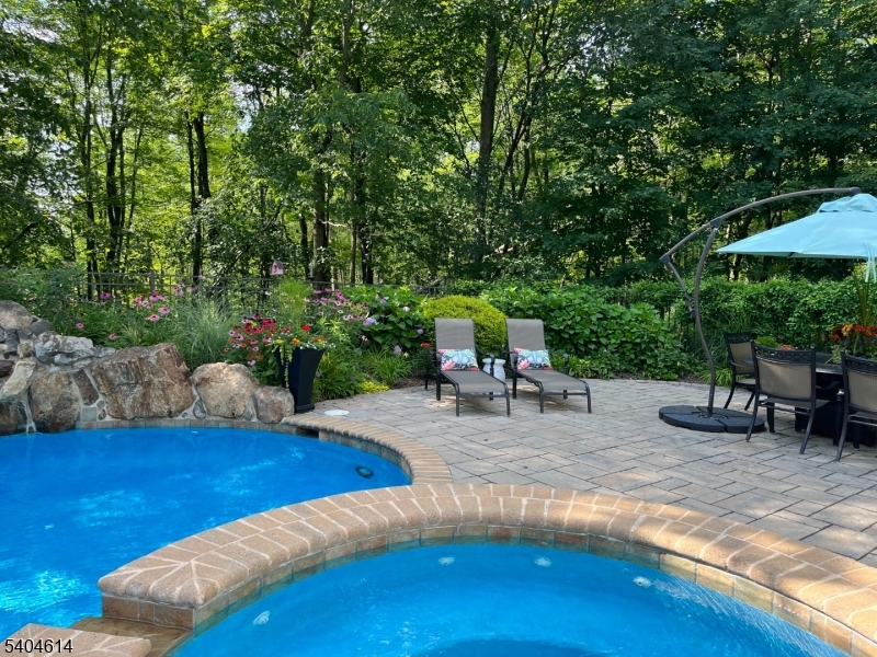 36 West Springtown Road Long Valley, NJ 07853 - Photo 47 of 50 a view of a backyard with swimming pool table and chairs under an umbrella