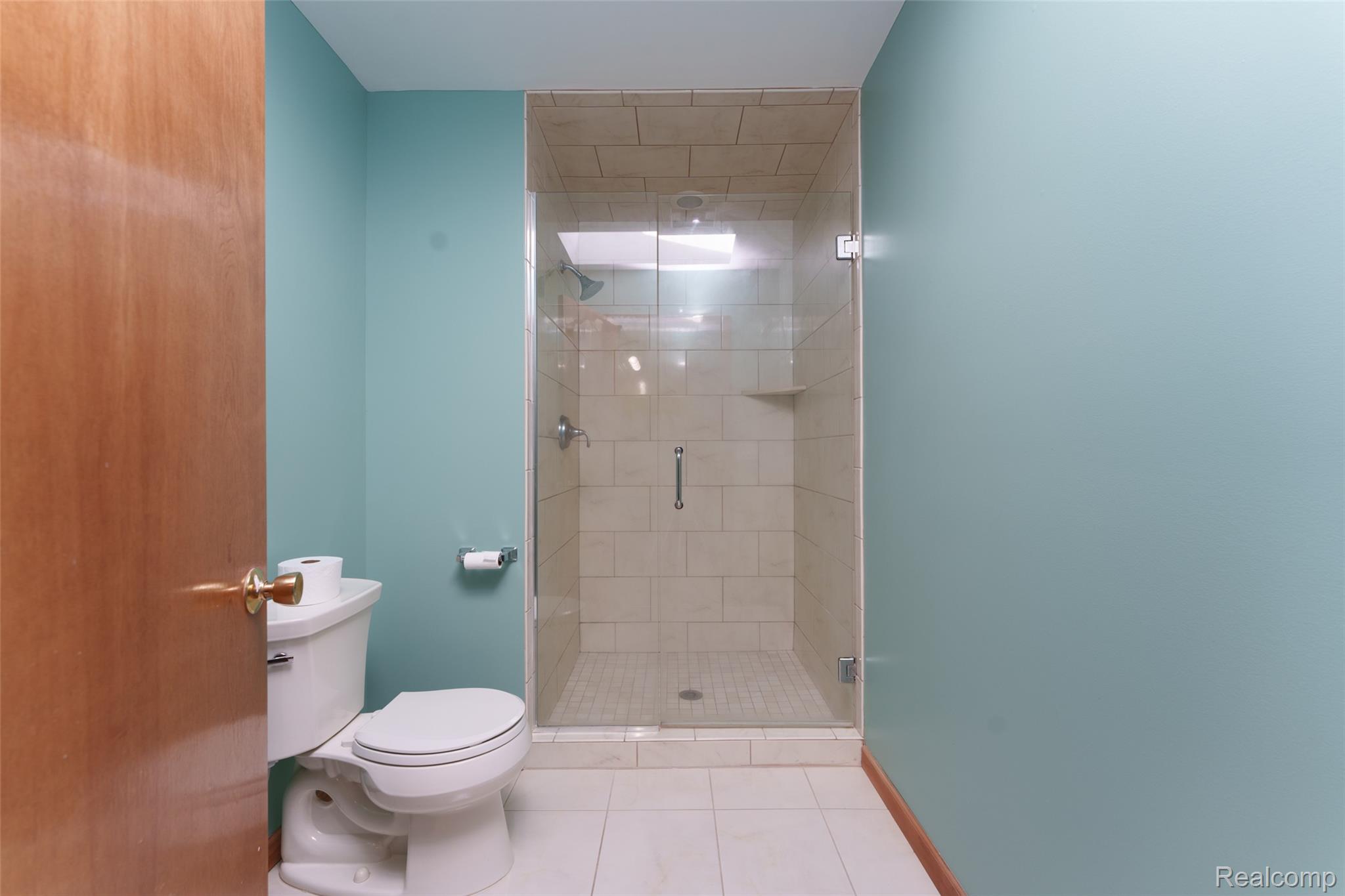 3166 Bigelow Road Howell, MI 48855 - Photo 21 of 50 Walk-in shower featuring a clear glass enclosure, tiled walls, and a built-in shower niche