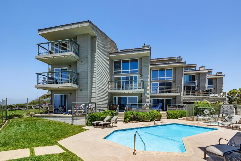 940 Sealane Drive, Unit 14 Encinitas, CA 92024 - Photo 30 of 45 a front view of a house with a yard table and chairs