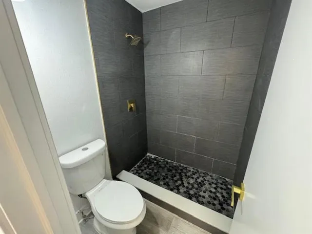 a bathroom with a toilet and a shower