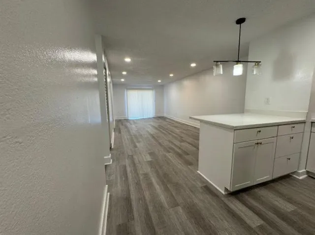 a view of a kitchen with a dishwasher and wooden floor