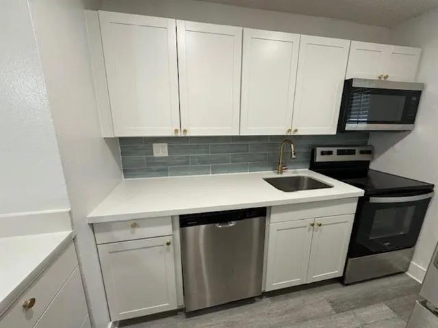 a kitchen with a sink and a stove top oven