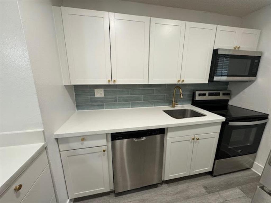 5525 Southwest 41st Street, Unit 306 Hollywood, FL 33023 - Photo 4 of 11 a kitchen with a sink and a stove top oven
