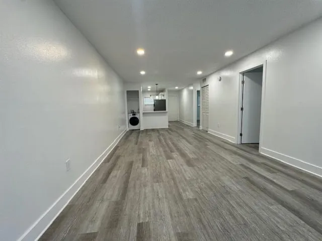 a view of a big room with wooden floor and a window
