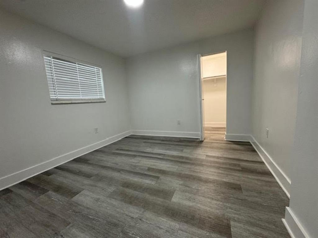 5525 Southwest 41st Street, Unit 306 Hollywood, FL 33023 - Photo 8 of 11 an empty room with wooden floor and windows
