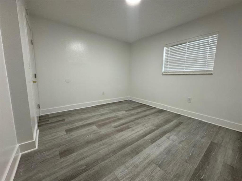 5525 Southwest 41st Street, Unit 306 Hollywood, FL 33023 - Photo 9 of 11 an empty room with wooden floor and windows