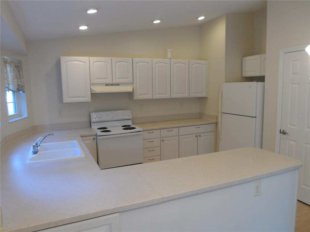 1221 Northwest 35th Avenue Gainesville, FL 32609 - Photo 6 of 16 a kitchen with white cabinets and white appliances