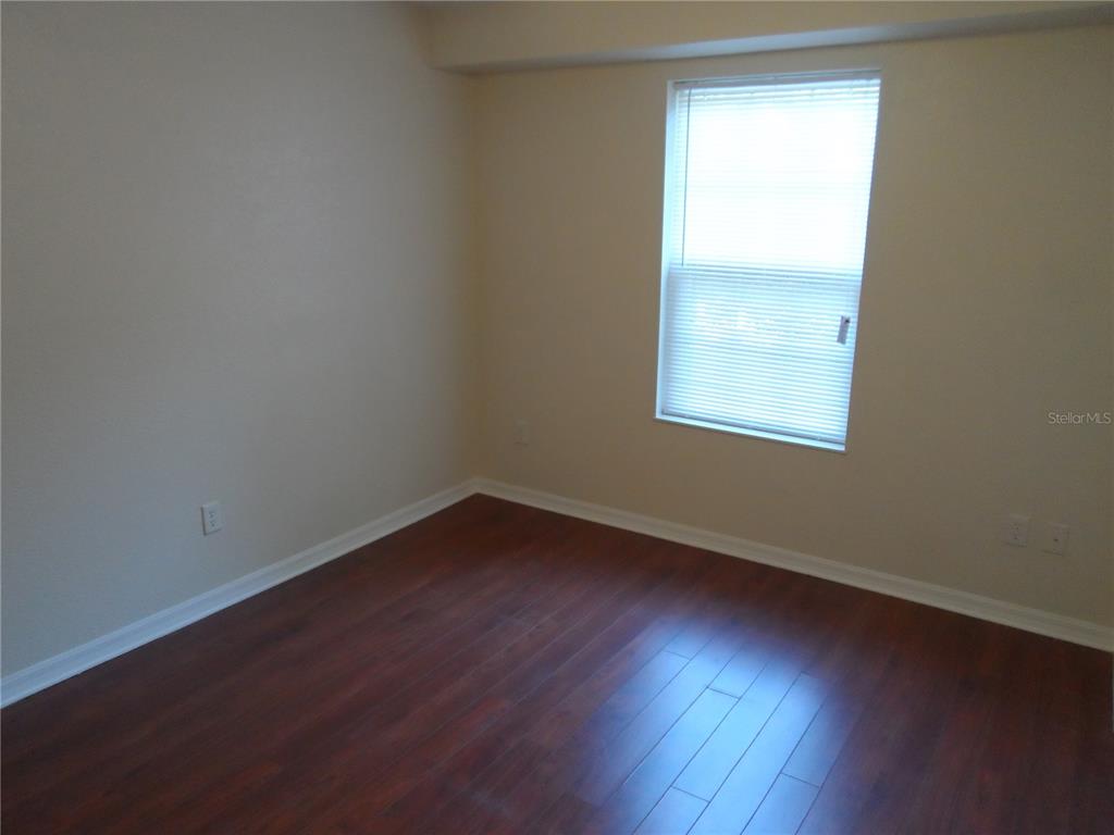 1221 Northwest 35th Avenue Gainesville, FL 32609 - Photo 7 of 16 an empty room with wooden floor and windows