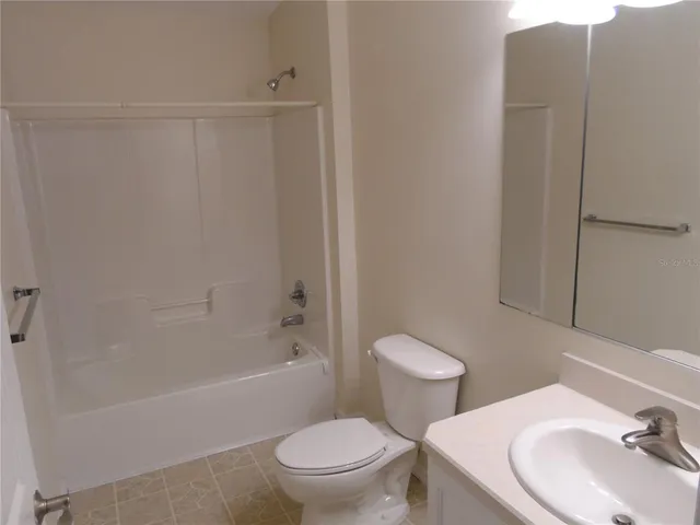 a white toilet sitting next to a bath tub