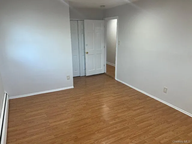 a view of an empty room with wooden floor