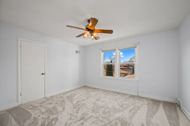 a view of empty room with window and ceiling fan