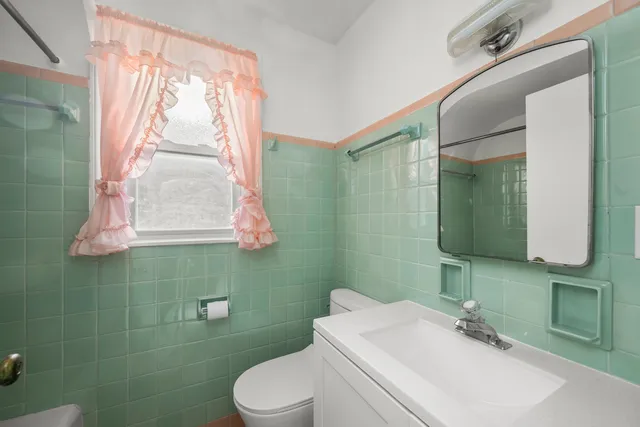 a bathroom with a sink a toilet and a mirror