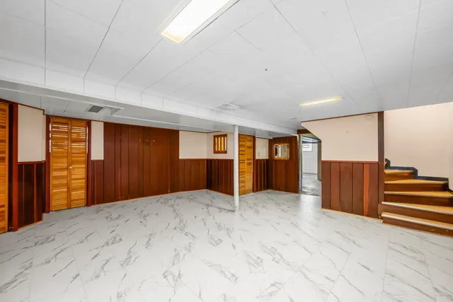 a view of an empty room with closet and windows