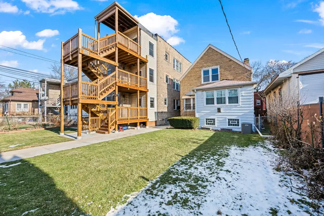 a view of a big house with a big yard and large trees