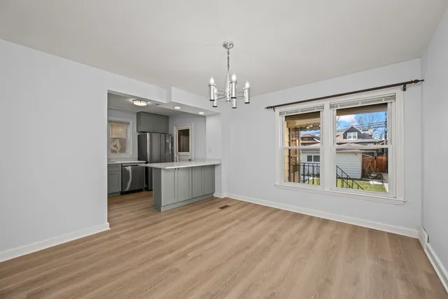 a view of a big room with wooden floor and a kitchen