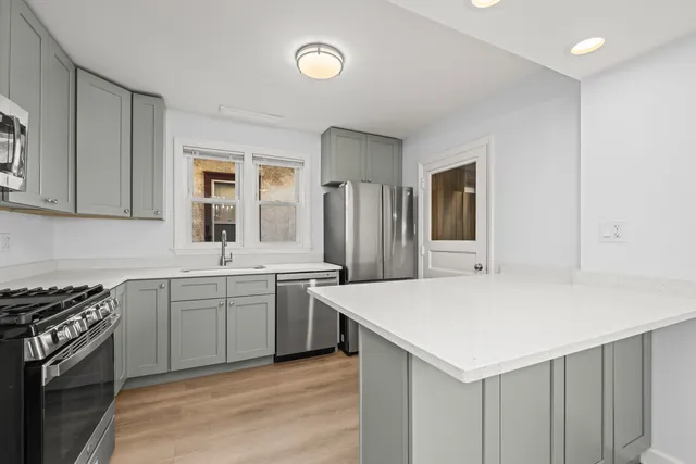 a kitchen with granite countertop a sink stove and refrigerator