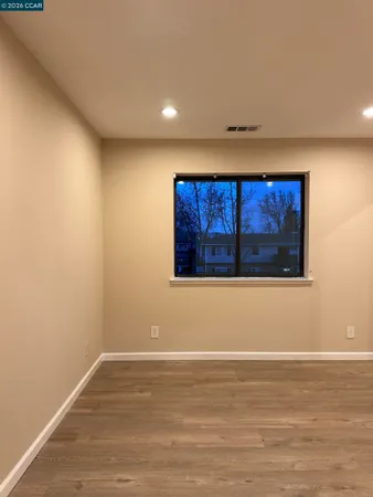 an empty room with wooden floor and closet area