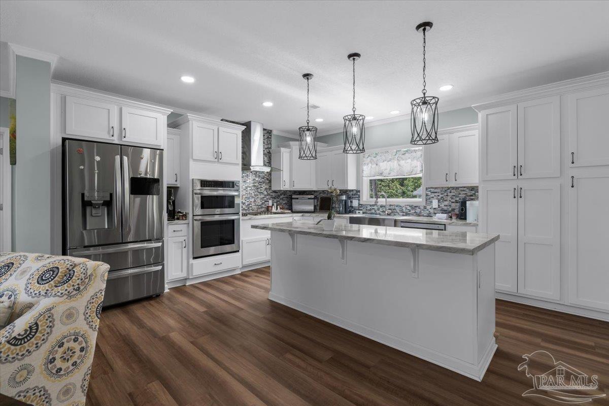 4955 Blue Ribbon Drive Milton, FL 32583 - Photo 1 of 32 a kitchen with stainless steel appliances kitchen island granite countertop a refrigerator a oven a sink with island and chairs